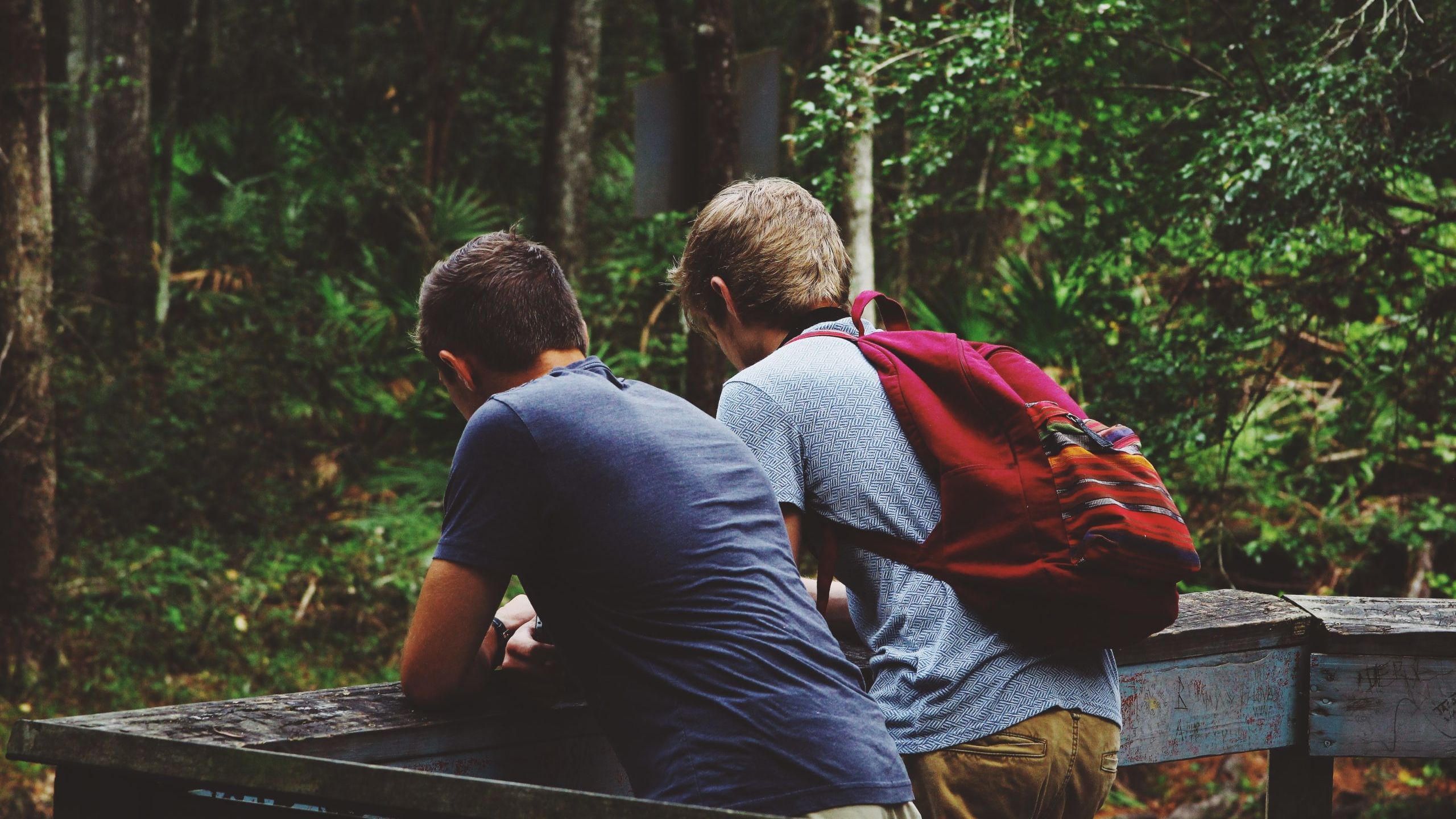 two men leaning on fence