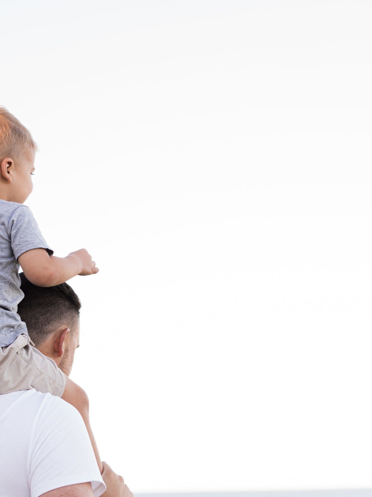 man in white shirt carrying boy