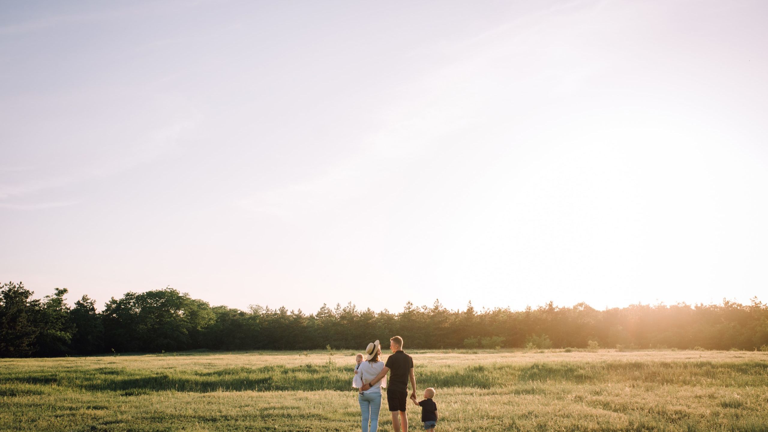 man and woman walking on green grass field during daytime