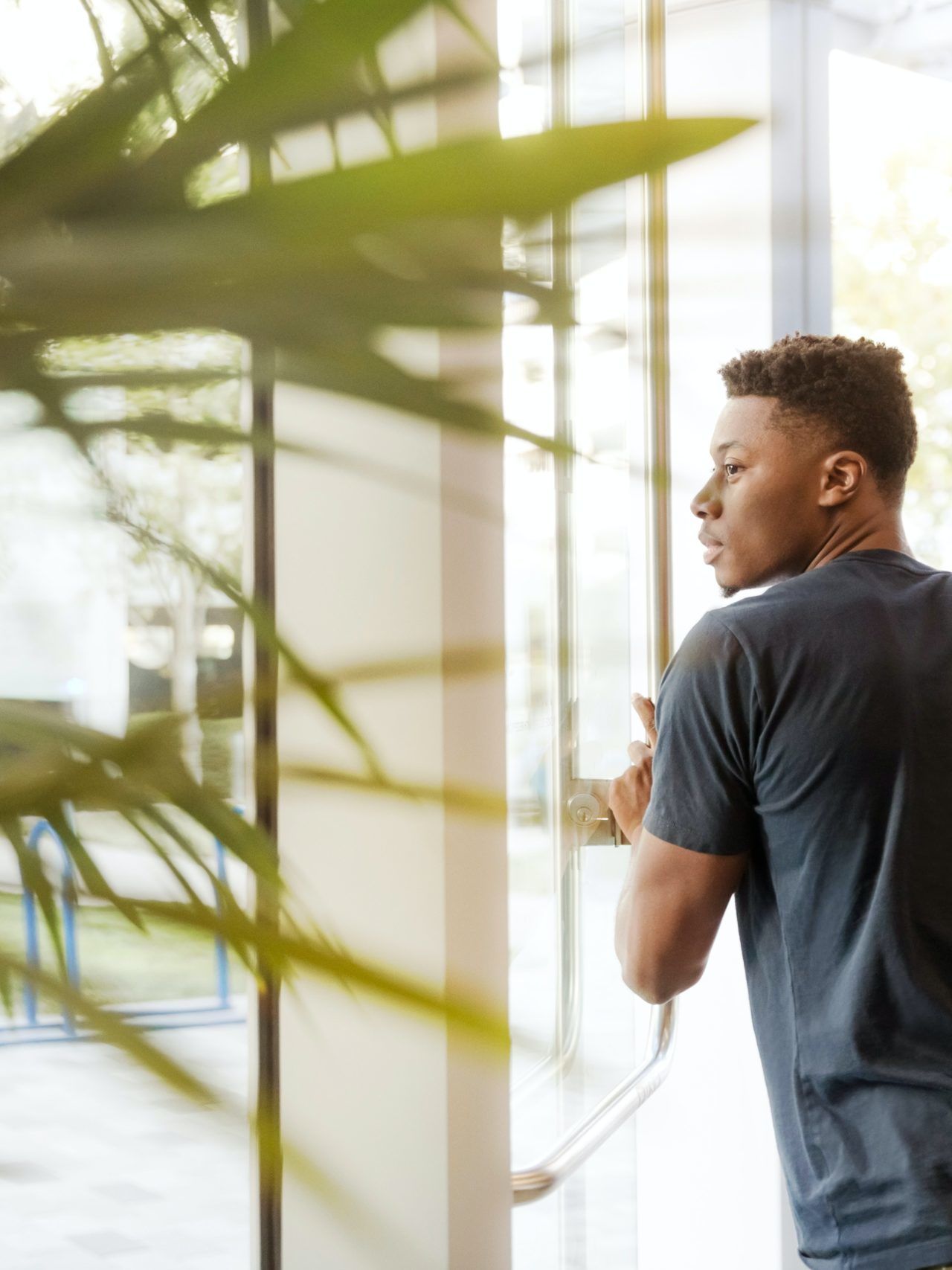 man holding glass door