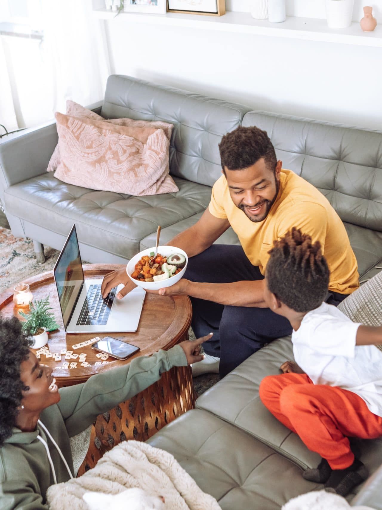 man in black crew neck t-shirt sitting on gray couch