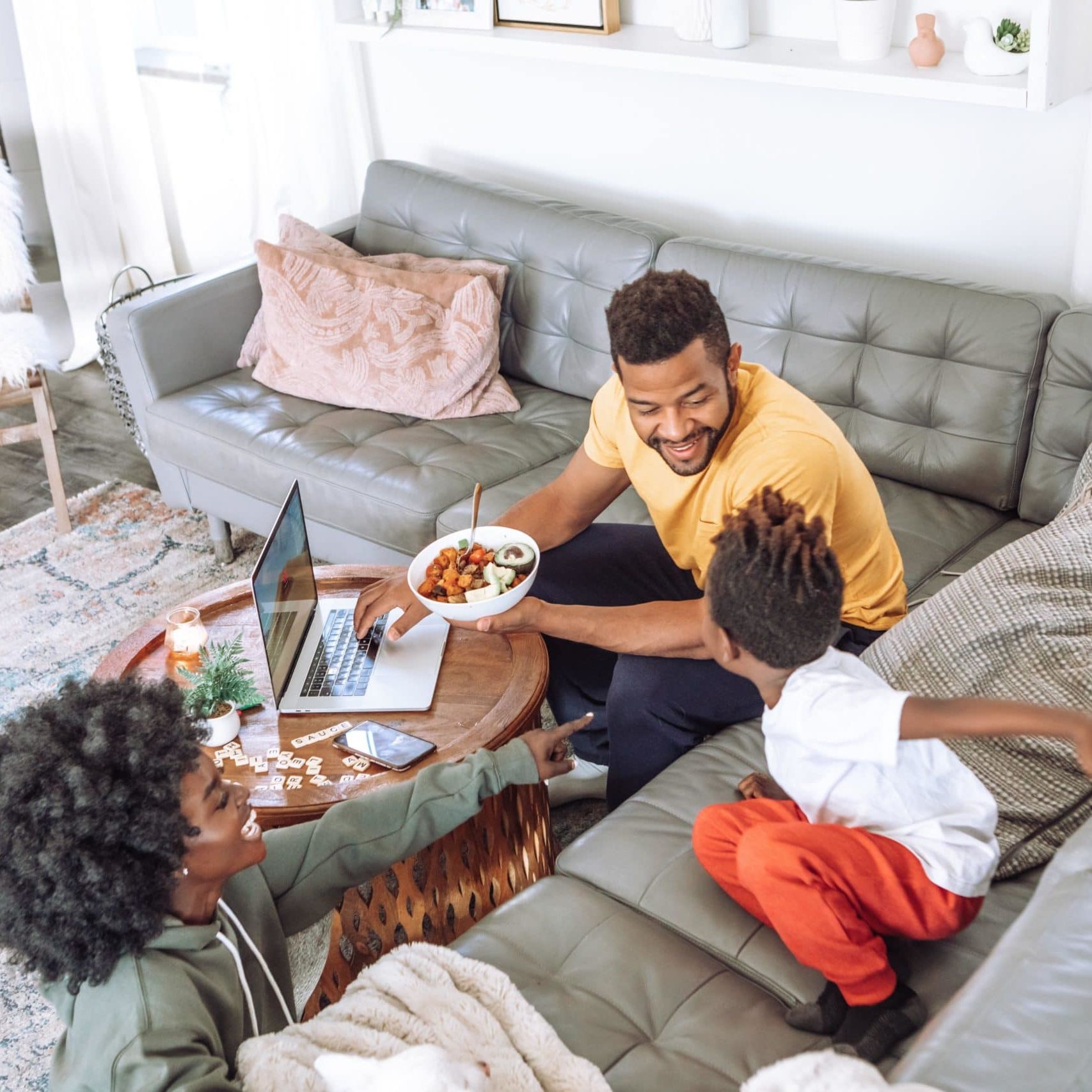 man in black crew neck t-shirt sitting on gray couch