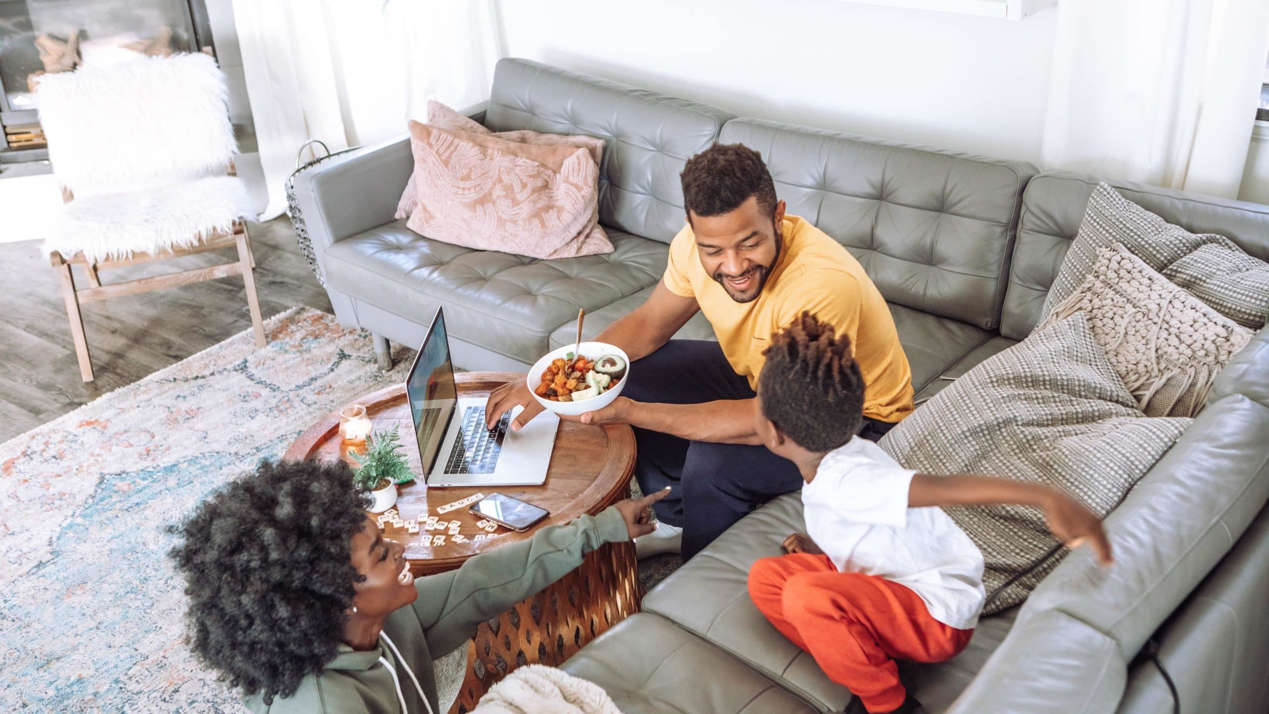 man in black crew neck t-shirt sitting on gray couch