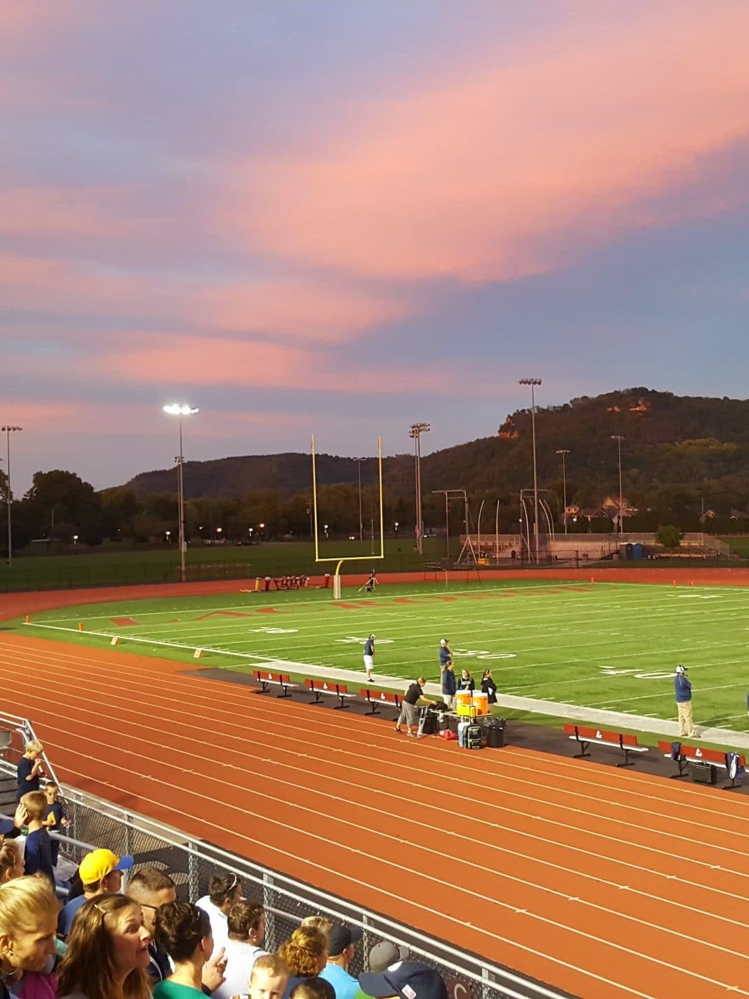 football players standing on field with crowd watching