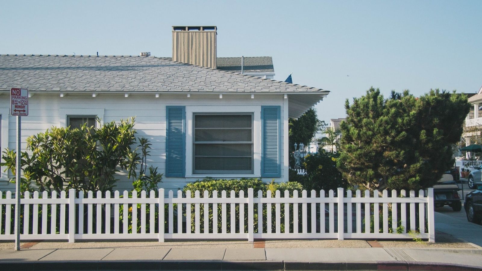 white and blue house beside fence