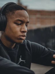 man in black nike hoodie wearing black headphones