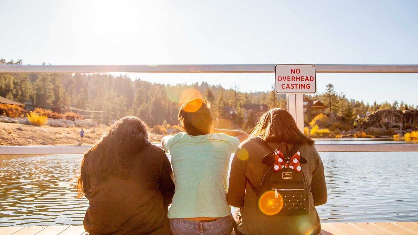 three people sitting on bridge