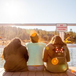 three people sitting on bridge