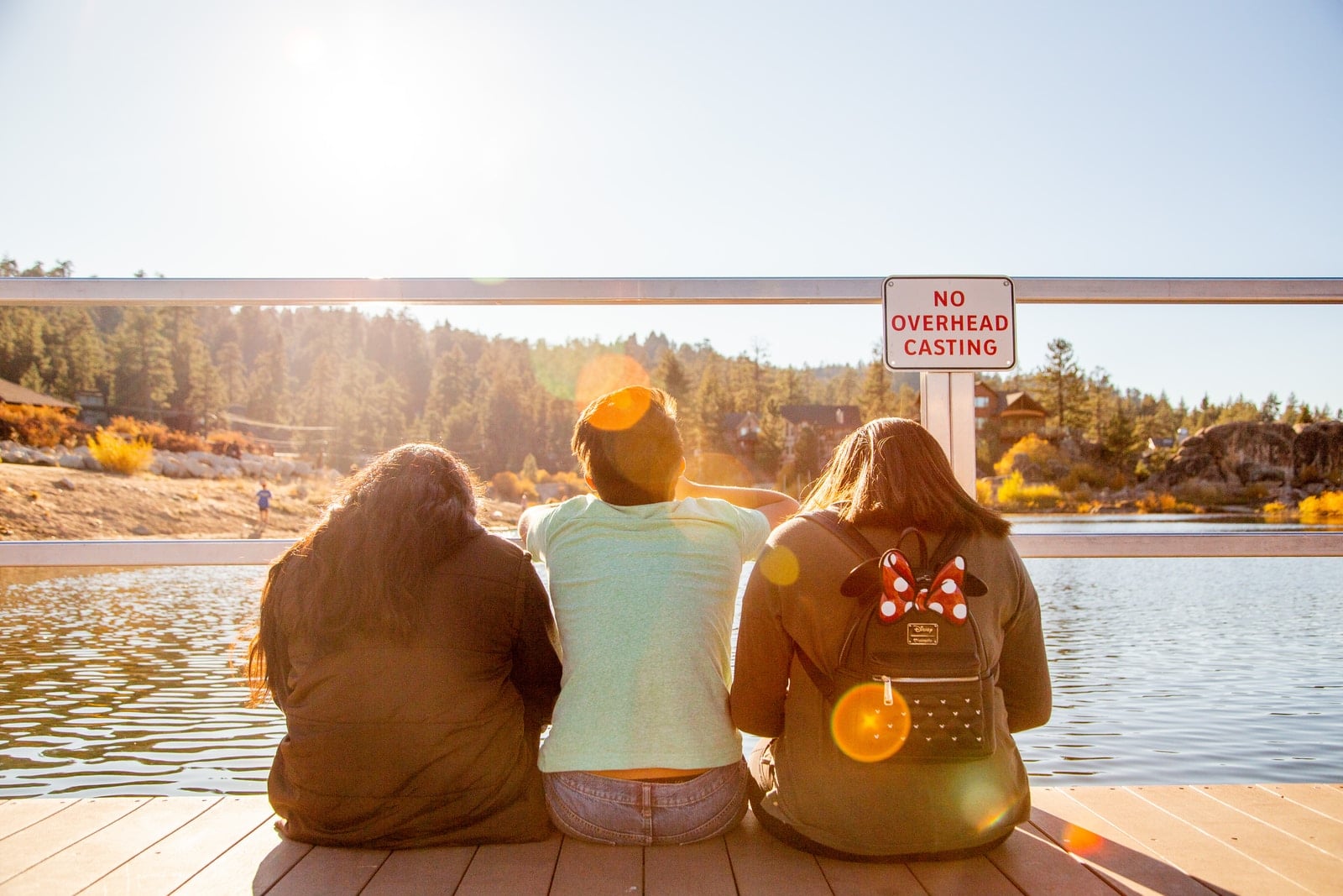 three people sitting on bridge