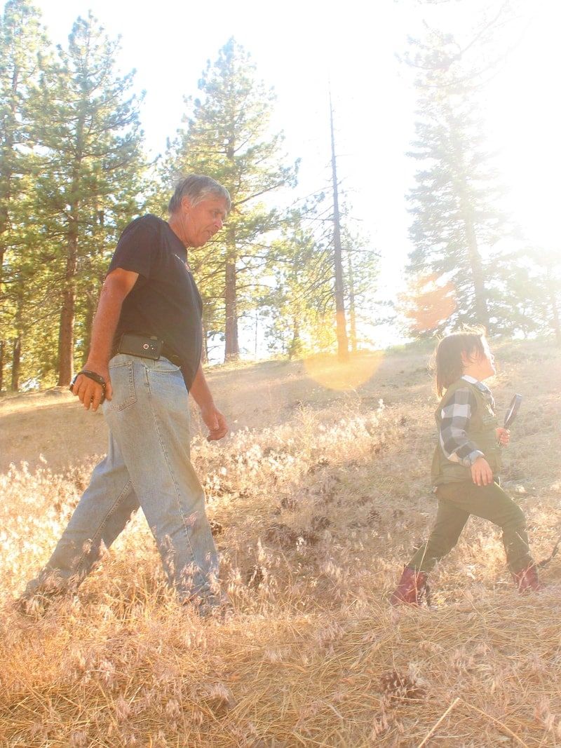 man in black t-shirt and blue denim jeans holding girl in black t-shirt