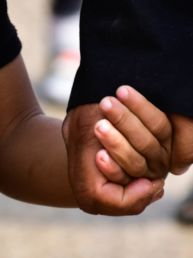 person in black t-shirt holding persons hand