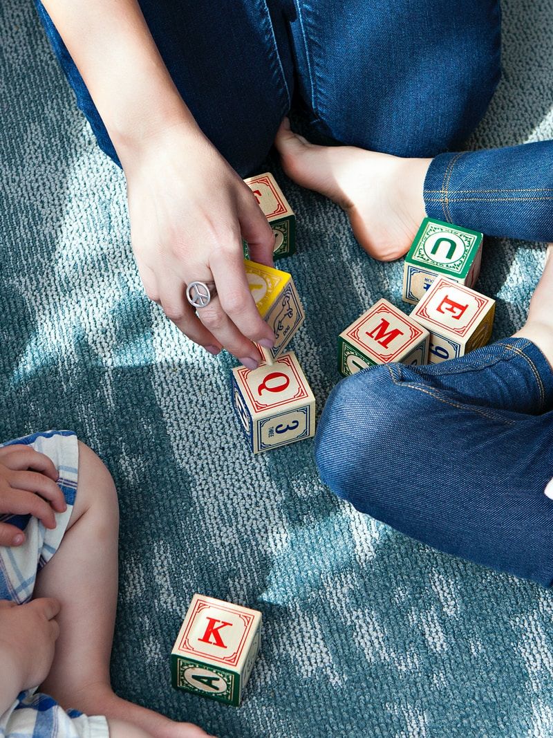 two toddler playing letter cubes