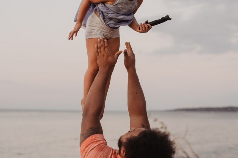 man in pink shirt lifting up girl