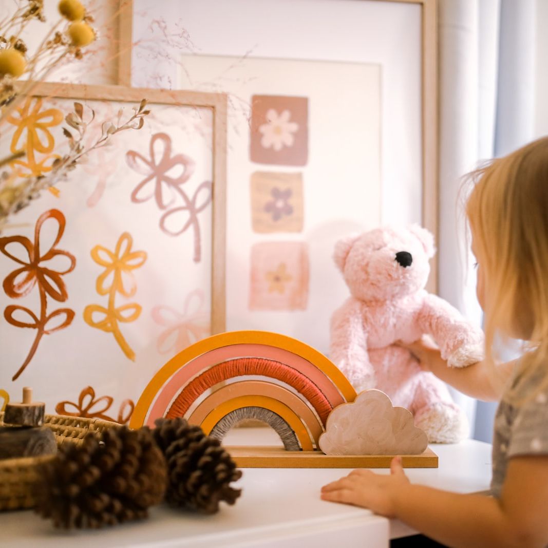 girl wearing grey shirt standing near framed artwork