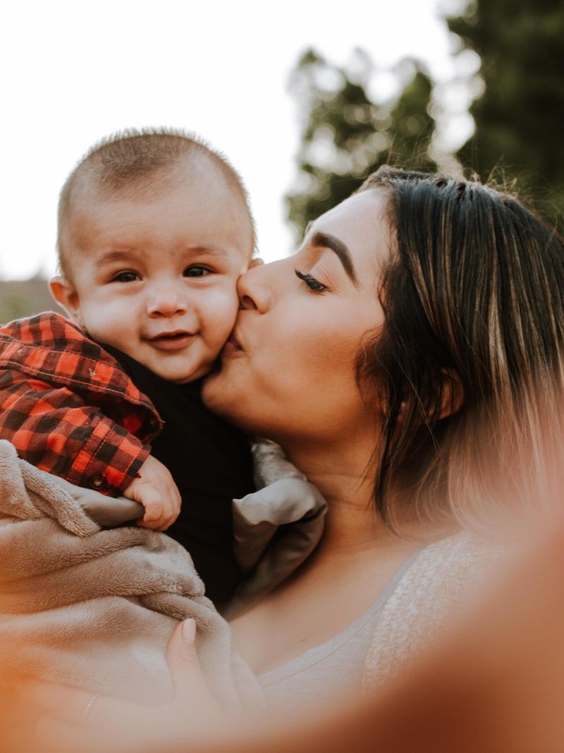 woman kiss a baby while taking picture