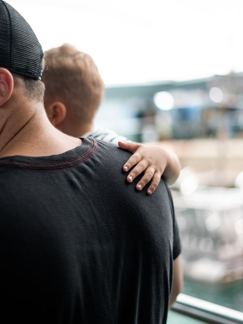 selective focus photography of man carrying baby