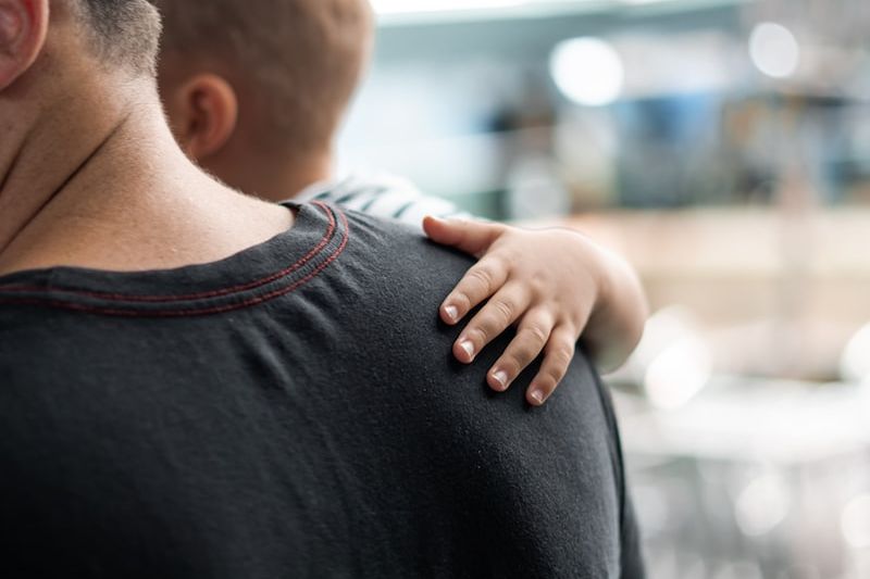 selective focus photography of man carrying baby