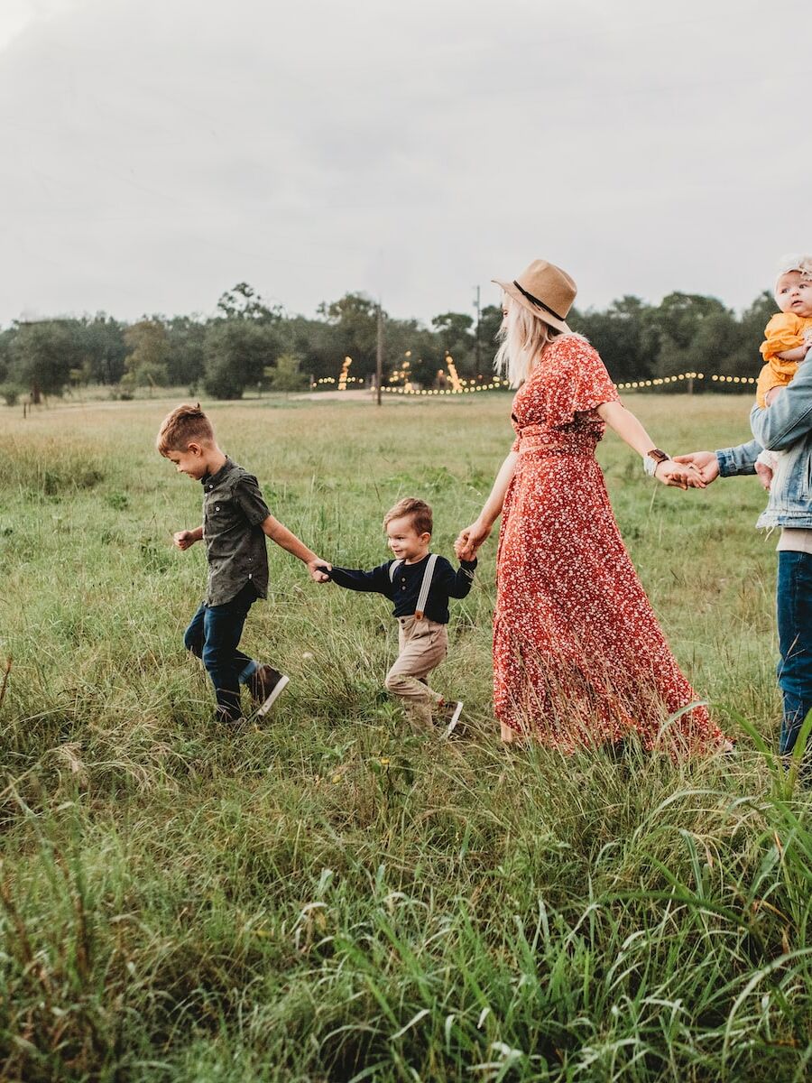 woman holding man and toddler hands during daytime