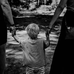 grayscale photo of woman in black dress holding child in black shirt