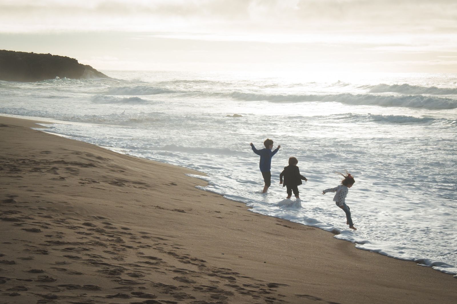 a group of people standing on top of a sandy beach