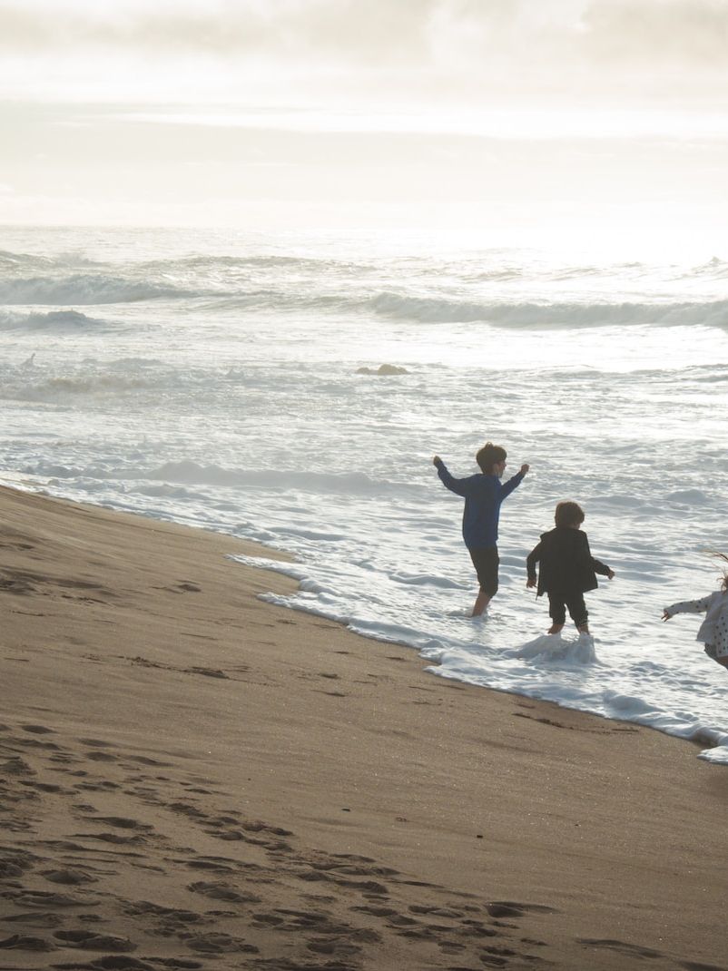 a group of people standing on top of a sandy beach