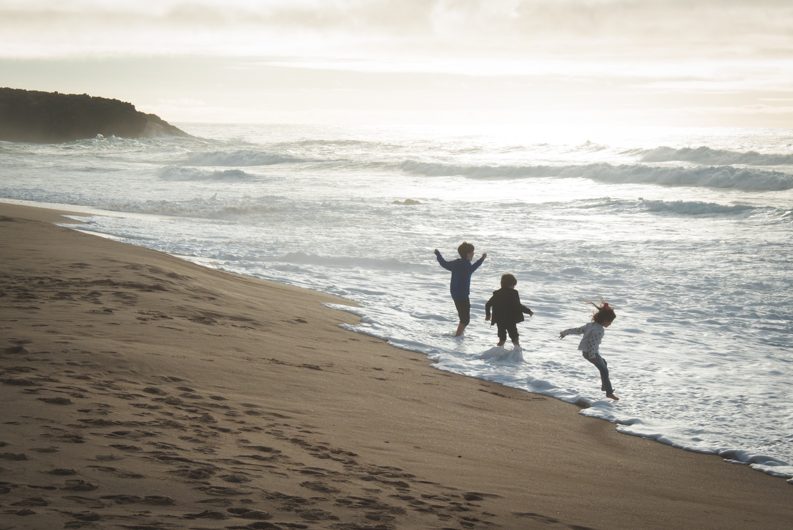 a group of people standing on top of a sandy beach