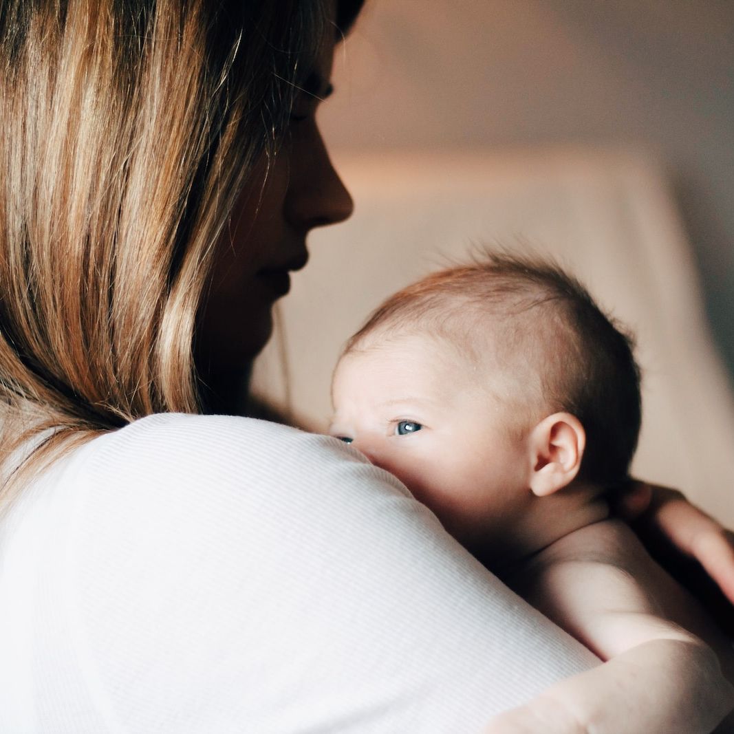 woman in white shirt carrying baby