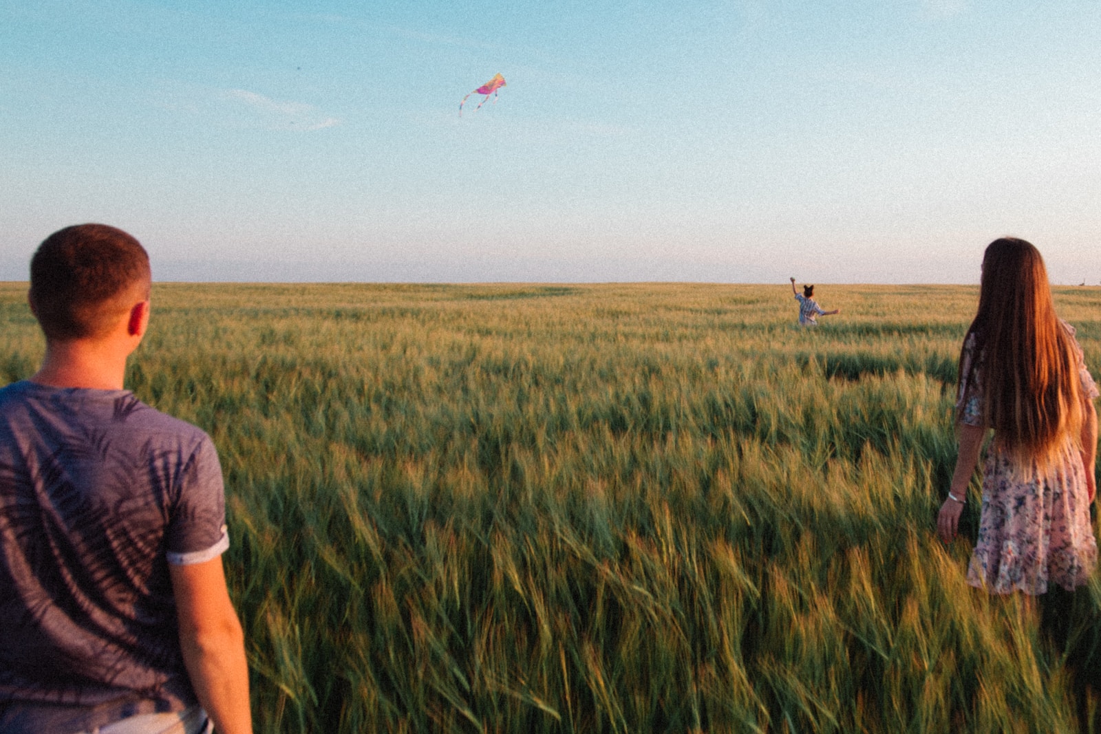 person in grey shirt standing on green grass field during daytime