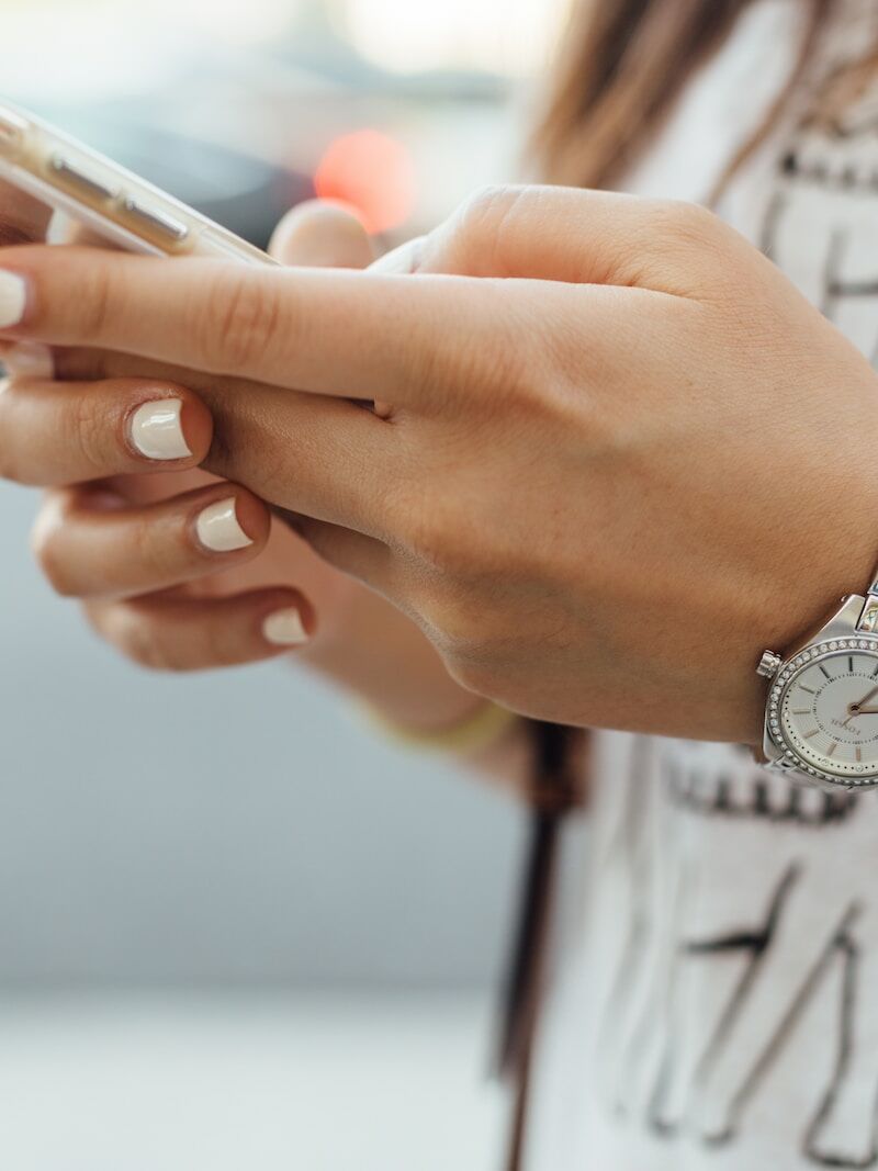 woman holding iPhone during daytime