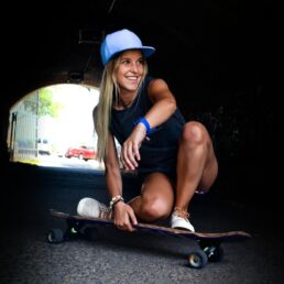 woman crouching while riding on skateboard during daytime shallow focus photography