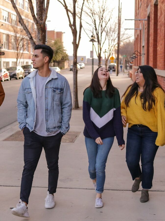 three men and laughing two women walking side by side