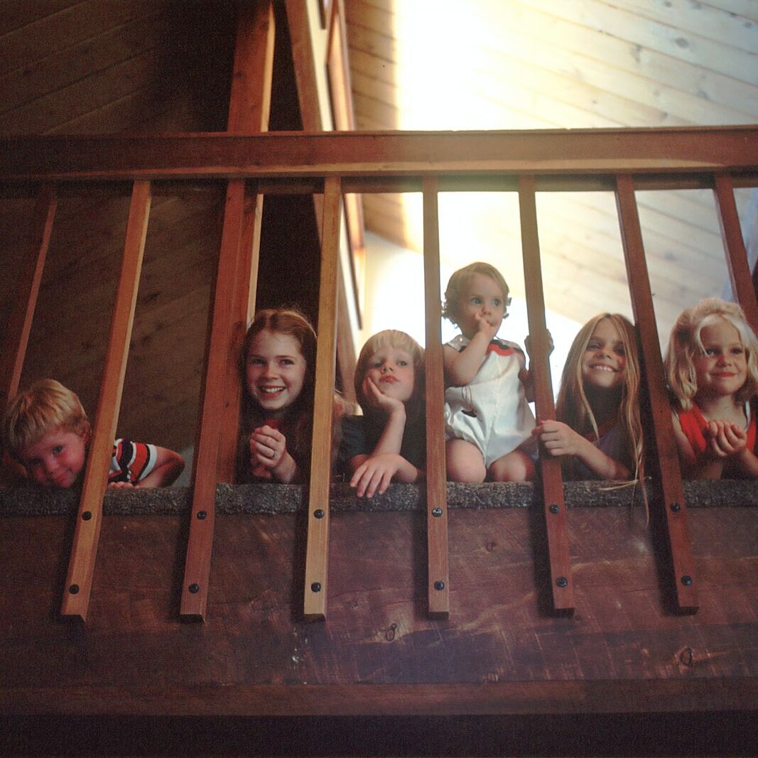 children peeking through railing