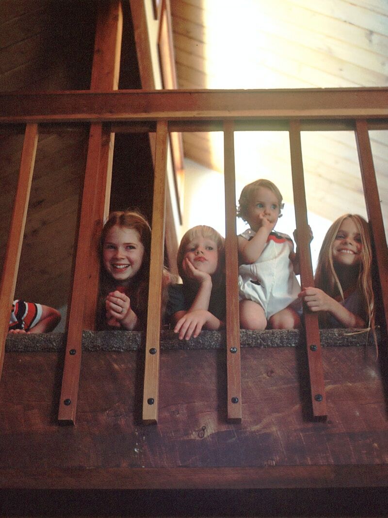 children peeking through railing