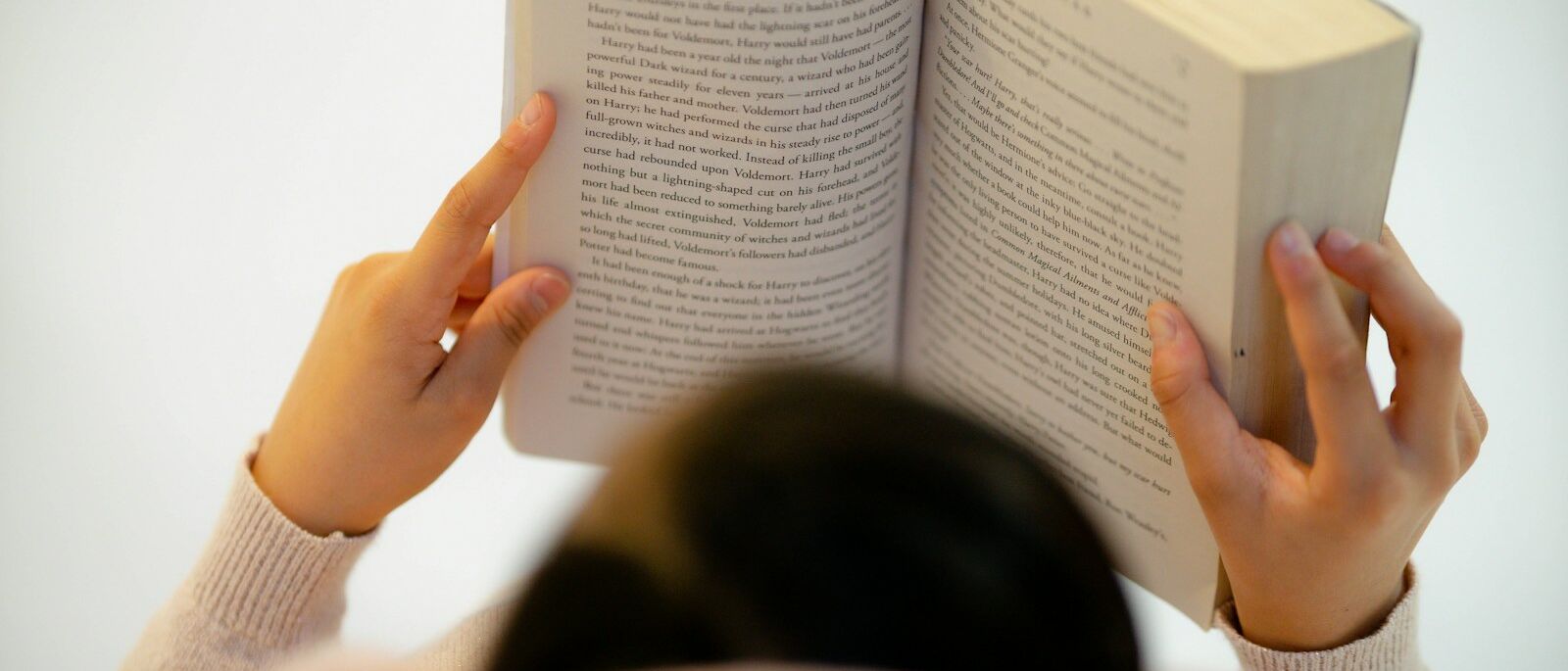 woman in white long sleeve shirt reading book