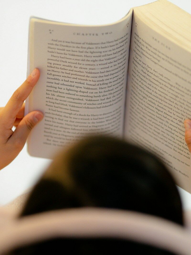 woman in white long sleeve shirt reading book